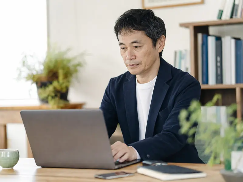 ノートパソコンで補助金情報を確認する経営者